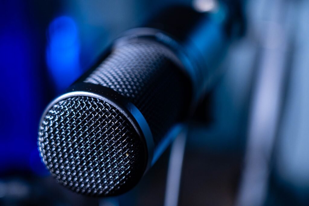 Spot publicitaire Detailed close-up of a professional studio microphone with a blurred blue background.